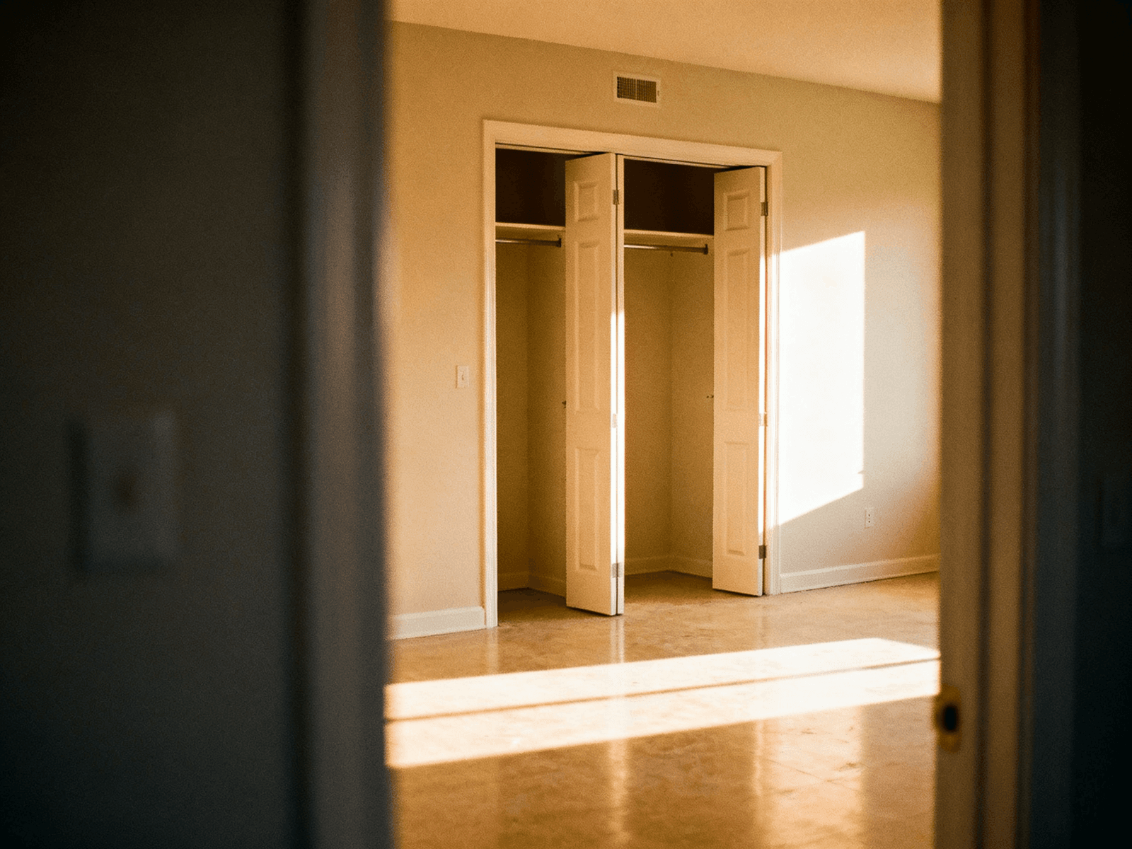 Completely empty apartment room after a move-out clean, floors bare and bright